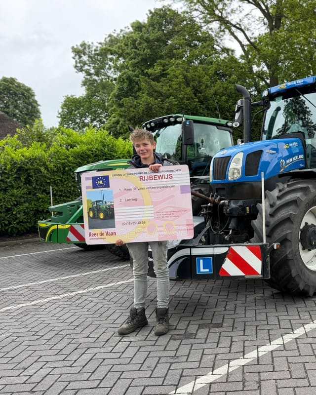 Geslaagde cursist met rijbewijsbord bij een blauwe lestrekker met L-borden
