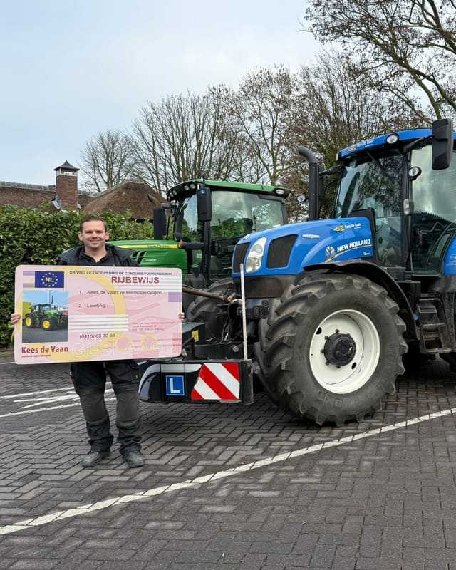 Geslaagd voor het T-rijbewijs: cursist met rijbewijsbord naast een blauwe lestrekker met frontgewicht