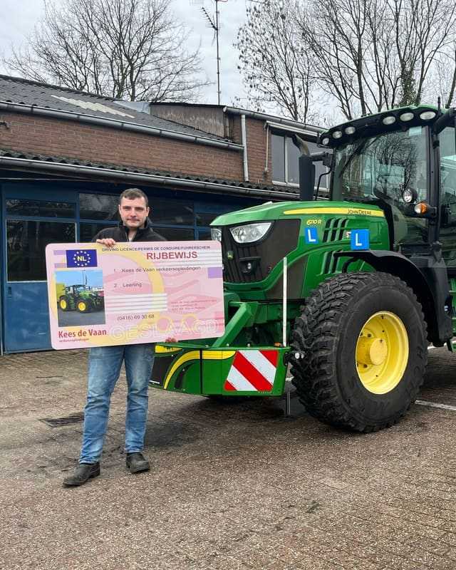 Geslaagd voor het T-rijbewijs: cursist met rijbewijsbord naast de groene lestrekker op het lesterrein