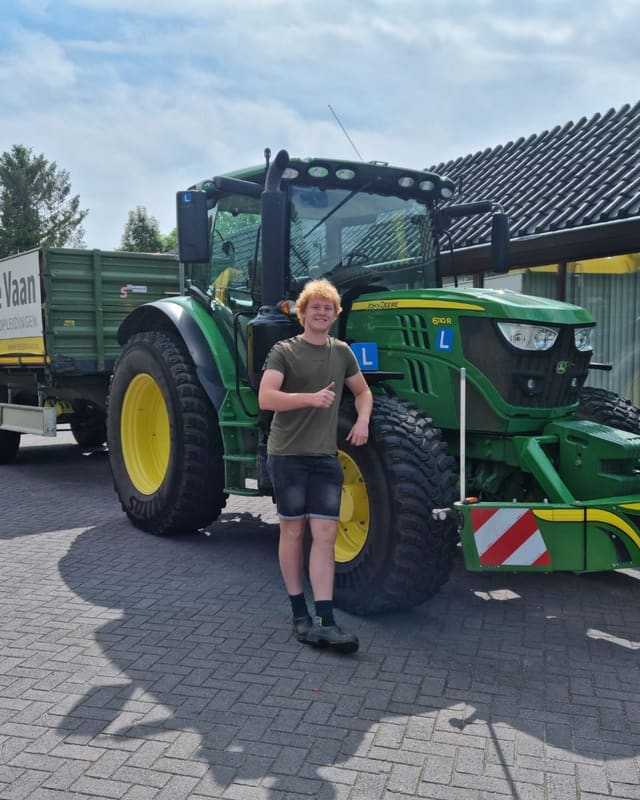 Geslaagd voor het T-rijbewijs: cursist steekt duim op naast een groene lestrekker