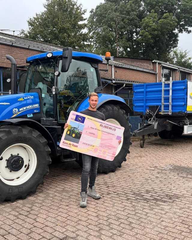 Geslaagde cursist houdt het rijbewijsbord schuin voor een blauwe lestrekker