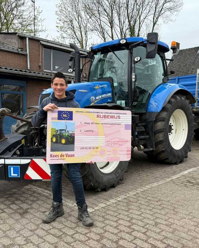 Geslaagd voor het T-rijbewijs: lachende cursist met rijbewijsbord voor een blauwe lestrekker